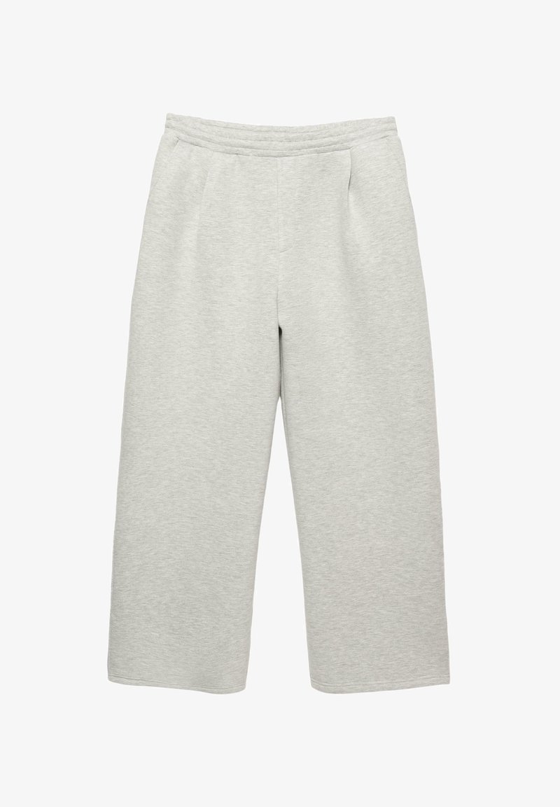 Svetlé šedé široké tepláky vyrobené z mäkkej tkaniny. Majú elastický pás a dve predné vrecká. Bez viditeľných vzorov alebo kovových prvkov.