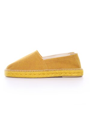 Espadrille de lienzo amarillo con un diseño slip-on, que cuenta con una suela de yute trenzado y una textura suave. Forma minimalista, sin acentos visibles.