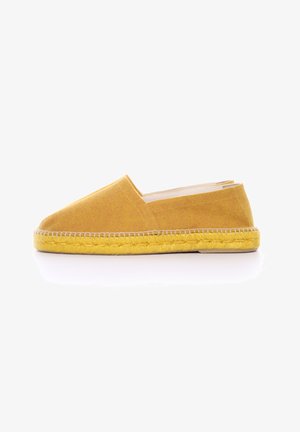 Espadrille de lienzo amarillo con un diseño slip-on, que cuenta con una suela de yute trenzado y una textura suave. Forma minimalista, sin acentos visibles.