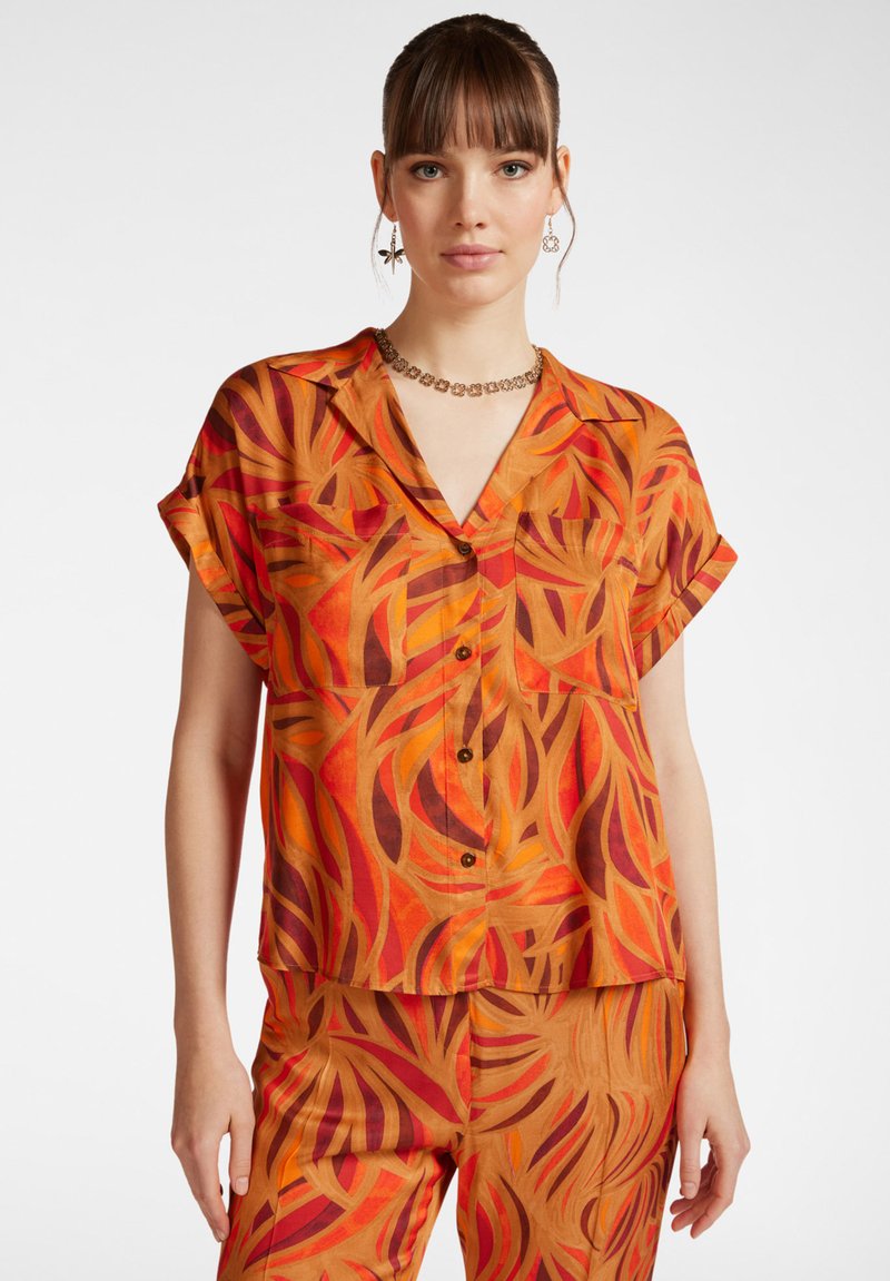 Camicia a maniche corte con bottoni e un motivo floreale multicolore in arancione, rosso e marrone. Realizzata in un tessuto leggero con una vestibilità comoda.