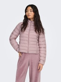 Doudoune rose clair avec un col haut, des coutures horizontales et une fermeture éclair à l'avant. Portée avec un pantalon assorti, doux et à jambes larges.