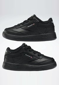 Černé sportovní boty vyrobené z syntetické kůže s texturovaným povrchem. Mají šněrování, polstrovaný límec a nenápadné logové detaily.