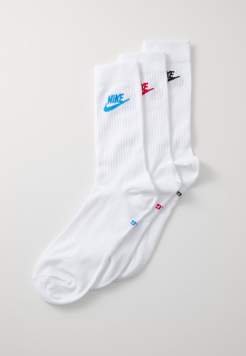 Fehér Nike zokni szett, amely három pár zoknit tartalmaz bordázott textúrával. Minden pár különböző logó színnel rendelkezik: kék, piros és fekete.