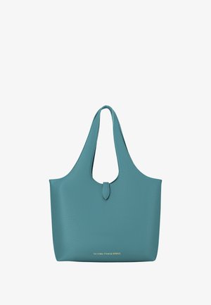 Tyrkis læder tote bag med en bred åben top, glat tekstur og et centralt udskåret håndtag. Har guld logo nederst.