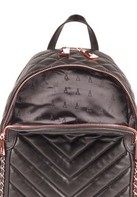 Mustavilla patjatasku, joka on valmistettu aitolederista. Varustettu vetoketjusulkimella, jossa on ruusukultaiset yksityiskohdat, ja kuvioitu sisusvuori.