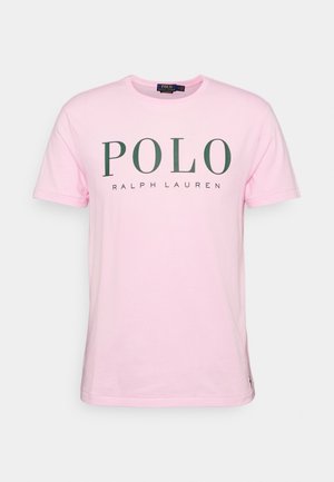 Helles rosa Baumwoll-T-Shirt mit kurzen Ärmeln, Rundhalsausschnitt und dunkelgrüner "POLO RALPH LAUREN" Textlogo auf der Vorderseite.