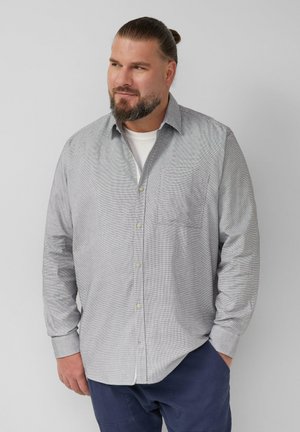 Grijs-wit gestreepte button-up shirt met een borstzak en opgerolde mouwen, gemaakt van een lichtgewicht stof. Draagt over een wit T-shirt.