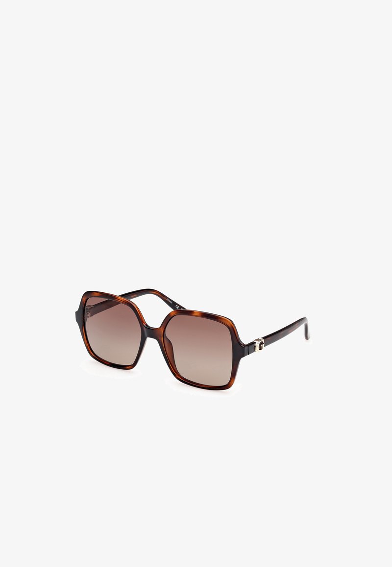 Oversized sunglasses with a brown tortoiseshell frame, gradient lenses, and metal logo detail on temples. Square shape with glossy finish.