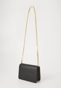 Svart læder crossbody taske med en struktureret form, forsynet med en guld kædetras og prægede logo detaljer på fronten.