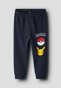 Mörkblå joggerbyxor i jersey med elastisk midja. Har tryckt Pokémon-logotyp, Pokéball och Pikachu-grafik på vänster lår.