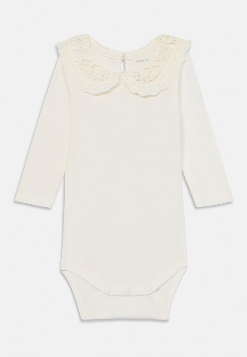 Long-sleeve baby bodysuit in cream, featuring a decorative lace collar, snap closure at the bottom, and a textured fabric design.
