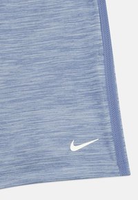 Modré športové šortky vyrobené z textúrovanej tkaniny, s bielym logom Nike na spodnej strane a šitými švami pozdĺž okrajov.