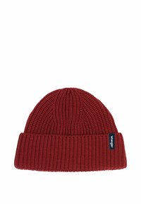 Cappello di lana rosso lavorato a maglia con una texture a coste e un risvolto. Presenta un'etichetta blu sul lato con testo bianco.