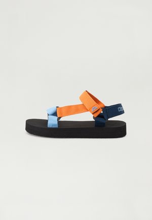 Černé ploché sandály s oranžovými, modrými a námořnickými popruhy. Disponují dvěma křížícími se textilními popruhy a silnou gumovou podrážkou.