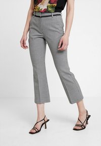 Rutiga grå skräddarsydda byxor med kort längd, med en mjuk textur, bälteshällor och sidofragor. Kombinationen med svarta remsandaler.