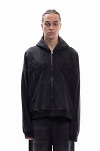 Μαύρο φούτερ με φερμουάρ και άνετη εφαρμογή, με κεντημένα αφηρημένα σχέδια στο εμπρός μέρος, μεγάλες τσέπες κα ι υφή υφάσματος.