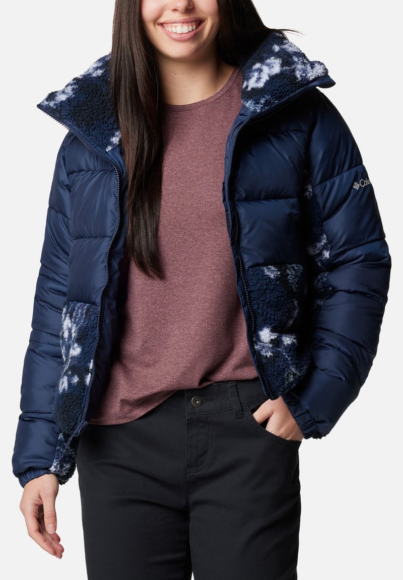 Veste rembourrée marine avec un doux revêtement en polaire à motifs sur le col et les poches. Dispose d'une fermeture éclair et d'une coupe classique.