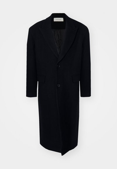 Melnas vilnas mētelis ar garu, taisnu dizainu, izgrieztiem labajiem atlociem, divām pogām un sānu kabatām. Gluda tekstūra un pielāgota piegriezuma.