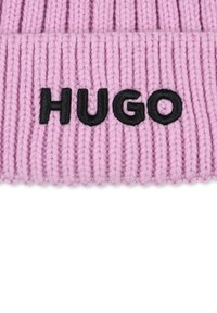 Roze gebreide beanie met ribbeltextuur, voorzien van een zwart geborduurd "HUGO" logo aan de voorkant.
