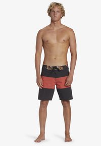 Pantaloni da surf con una cintura a stampa floreale, caratterizzati da un design a blocchi di colore in grigio scuro e corallo. Realizzati in materiale leggero, sono di lunghezza al ginocchio.
