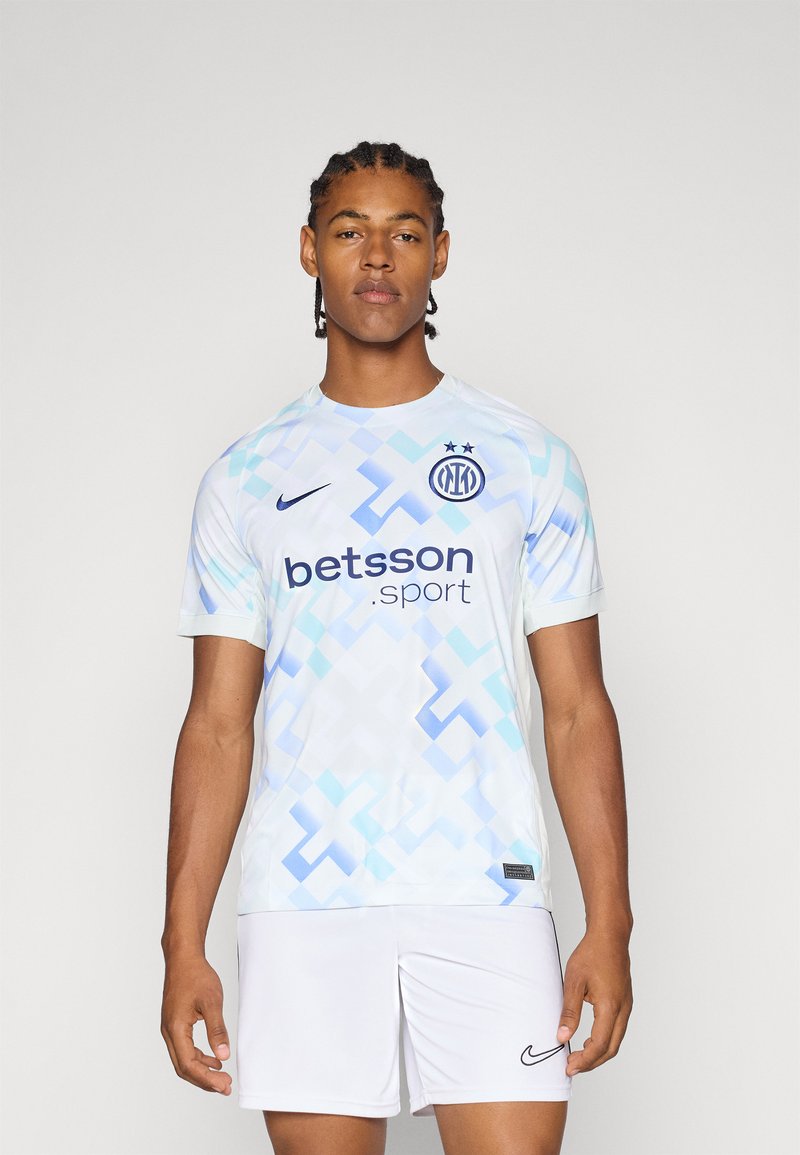 Maillot de soccer à manches courtes bleu clair avec un motif géométrique abstrait, logo bleu foncé et texte "betsson.sport". Associé à un short blanc.