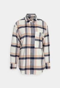 Langekleurig geblokt overhemd in roomwit, marineblauw en bruin. Voorzien van een knopenlijst aan de voorkant, een klassieke kraag en een borstzak met een patchworkontwerp.