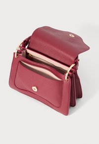 Geantă de mână din piele burgundy cu un finisaj texturat, având un sistem de închidere cu clapetă, un compartiment principal și un accent din metal auriu.