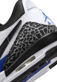 Sneaker fekete, fehér és kék színekben. Szintetikus anyag, szürke elefántmintás részletekkel és látható légpárnás egységgel.