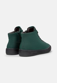 Groene hoge sneakers met een textuurstof bovenkant en zwarte rubberen zool, die een modern ontwerp en vetersluiting laten zien.