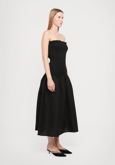 Zwarte strapless jurk met een getextureerde, aansluitende bodice en een vloeiende A-lijn rok, voorzien van een gerimpelde halslijn en zachte stof.