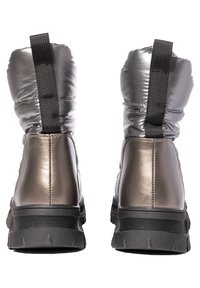 Botas de tobillo gris metálico con un exterior liso y acolchado, detalle de panel elástico negro y suela de goma negra texturizada.