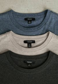 Trei tricouri cu guler rotund în culorile gri închis, gri deschis și bleumarin. Realizate dintr-un material moale, cu etichete cu "REISS" și marcaje de mărime.