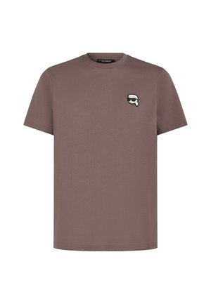 Hnedé bavlnené tričko s krátkymi rukávmi, s malým bielym grafickým logom na ľavej hrudi. Okrúhly výstrih, minimalistický dizajn.
