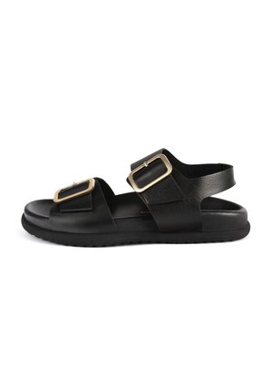 Zwarte leren sandalen met twee brede banden en gouden rechte gespen, een platte zool en een getextureerde voetbed voor comfort.