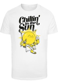 Hvit bomull T-skjorte med et grafisk motiv av en smilende sol i en stol, som holder en drink, med teksten "Chillin' in the Sun" i svart.