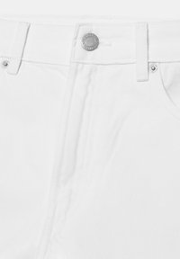 Nahaufnahme von weißen Jeans aus Denim mit Metallknopf und Nieten am Bund und an den Taschenrändern.