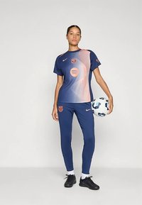 Námornícky futbalový dres s krátkym rukávom a dlhými nohavicami. Má prechodový dizajn s oranžovými akcentmi, klubovým logom a loptou.