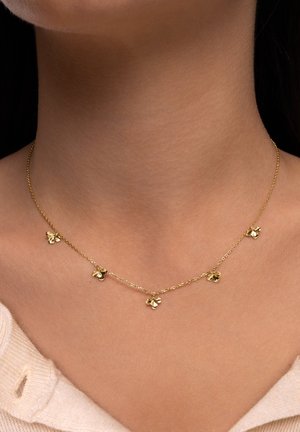 Goldene Halskette mit fünf kleinen Blumenanhängern, zarten Gliedern und einer glatten, glänzenden Oberfläche auf den Blumen.