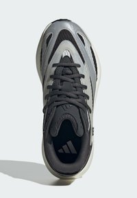 Čierne a sivé športové topánky s textúrovaným sieťovaným zvrškom, reflexnými akcentmi a odpruženou podrážkou. Viazanie na šnúrky s logom.