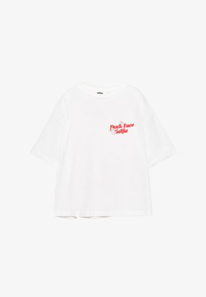 Bela kratka majica s kratkimi rokavi z rdečim napisom "Duck Face Selfie" in majhnimi ilustracijami rok na zgornjem levem delu prsnega koša.