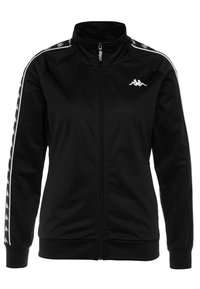 Veste de survêtement noire zippée avec logo blanc sur la poitrine et bandes blanches répétées avec logo courant le long des manches.
