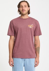 Bordeauxfarbene T-Shirt mit kurzen Ärmeln aus weichem Stoff und rundem Ausschnitt. Verfügt über ein gelbes Grafiklogo auf der Brust und eine lässige Passform.
