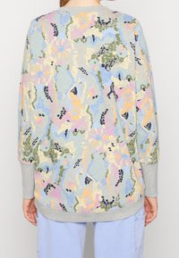 Lätt sweatshirt med ett flerfärgade blommönster i pastellnyanser på en strukturerad bakgrund samt ribbade grå ärmar och nederkant.