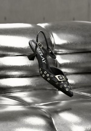 Pantof negru slingback cu vârf ascuțit, prevăzut cu căpușe argintii și o cataramă decorativă. Confecționat dintr-un material texturat, cu un toc mic tip bloc.