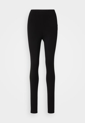 Svarta leggings med smal passform, hög midja och slät tyg. Inga synliga sömmar eller mönster, med en enkel och minimalistisk design.
