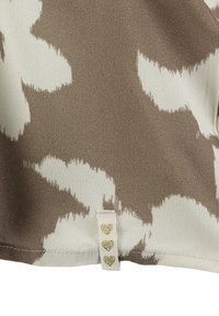 Tessuto a motivo marrone e crema con una texture in raso, caratterizzato da un orlo cucito e un'etichetta con tre cuori dorati.