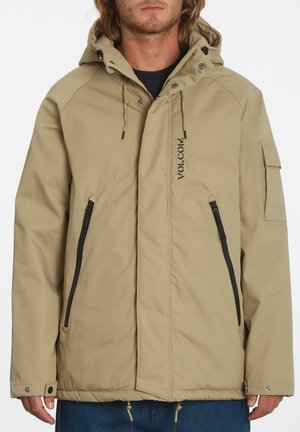 Chaqueta con capucha beige con cierre frontal, dos bolsillos con cremallera y un logo. Presenta cordones ajustables y una tela texturizada.