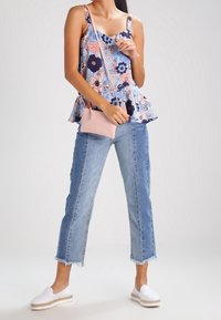 Blomstret peplum-top i blå, pink og marineblå; lys pink crossover taske; lyseblå cropped jeans; hvide slip-on espadriller med jute trim.