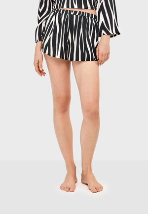 Shorts à rayures noires et blanches avec une taille élastique, offrant une coupe décontractée et une texture lisse, longueur au-dessus du milieu de la cuisse.