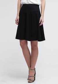 Schwarzer knielanger Rock mit einem breiten, elastischen Bund und einem schwingenden Design. Glattes Material ohne sichtbare Muster oder Verzierungen.